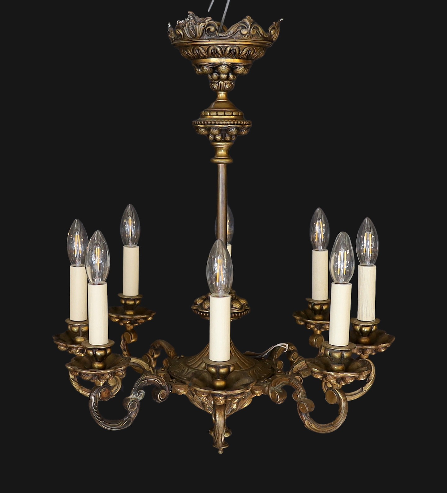 An early 20th Century Austrian bronze eight light chandelier, with scrolling branches and planished ball motifs, height 69cm. width 48cm